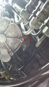 The location of the bottom bolt on the vacuum pump