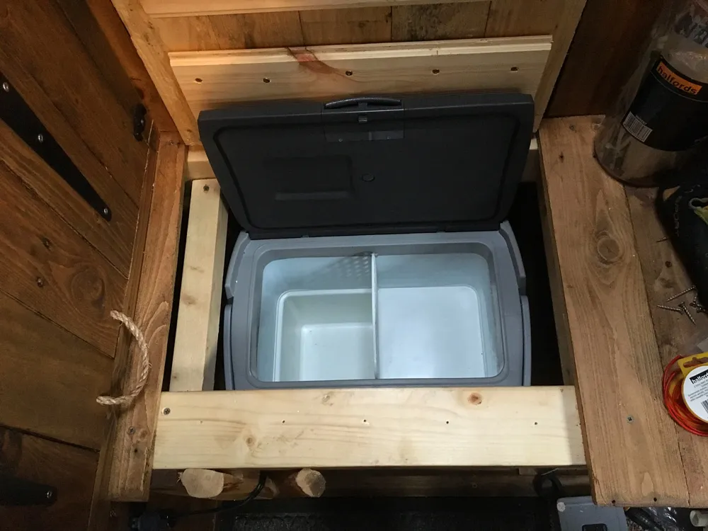 The seat hinges up to allow access to the fridge